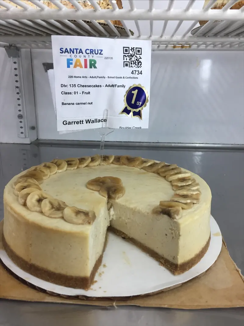 Garrett’s banana caramel nut cheesecake ringed with caramelized banana slices, cut open, with a first-place sticker on its entry tag