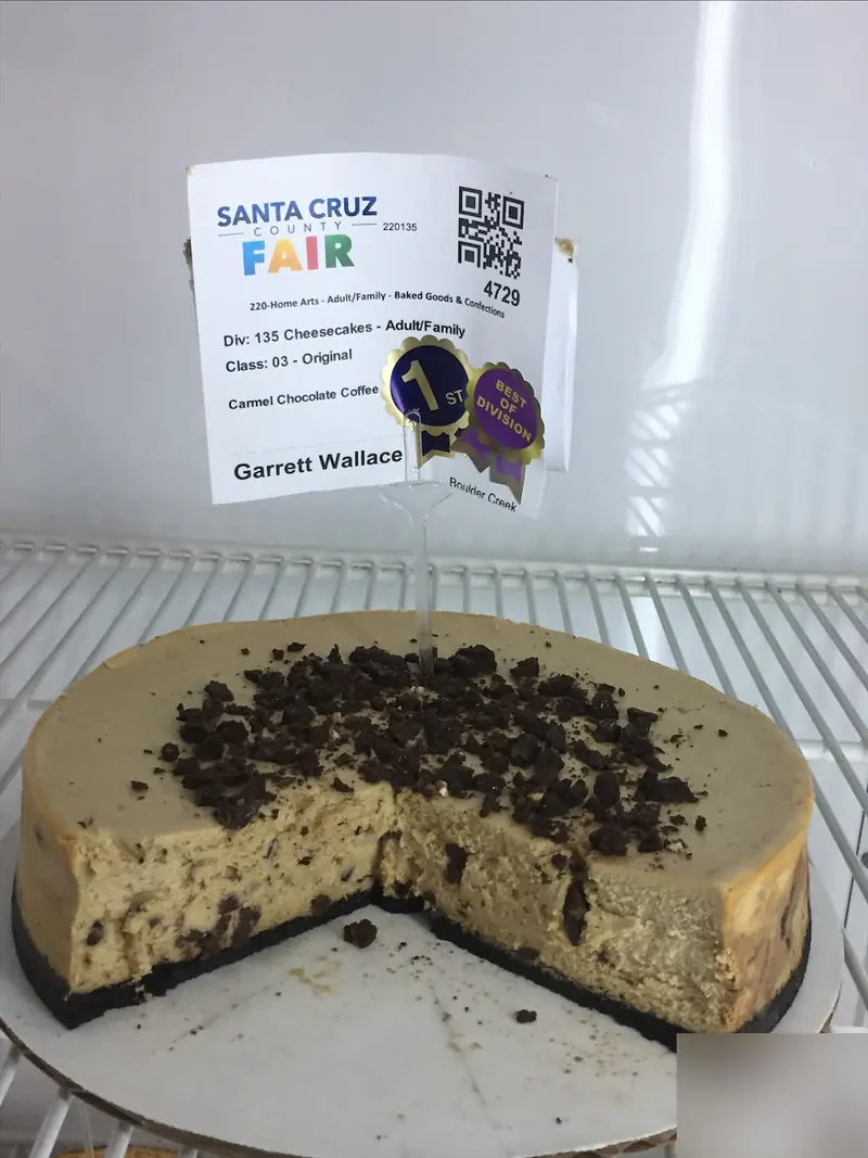 Garrett’s caramel chocolate coffee cheesecake on a chocolate cookie crust, topped with chocolate crumbles, with a first-place and a Best of Division sticker on its entry tag