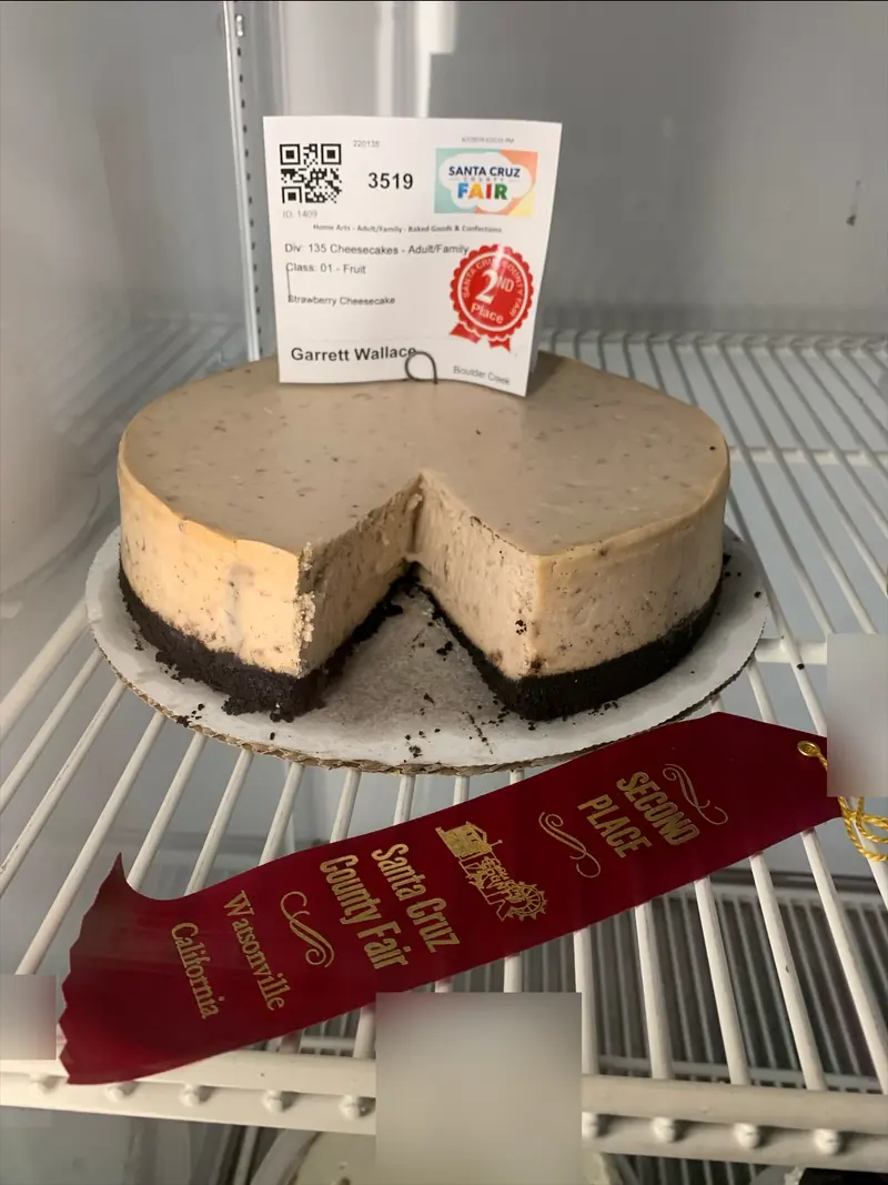 Garrett’s strawberry cheesecake on a chocolate cookie crust, cut open, with its entry tag and a red second-place ribbon